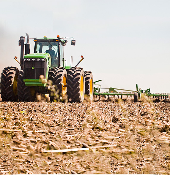Green tractor tilling field